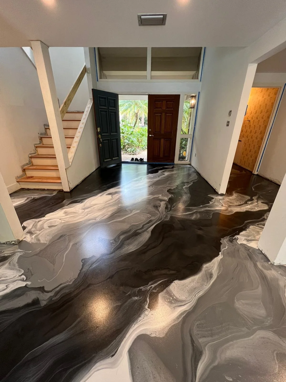 Black and white metallic epoxy floor in a home entryway